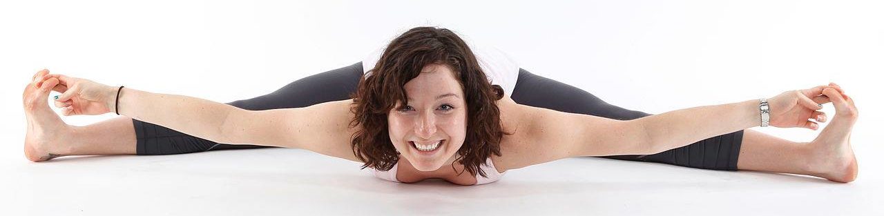 Photo graph of a women laying flat while in a "wide leg forward fold" yoga pose to illustrate, "
