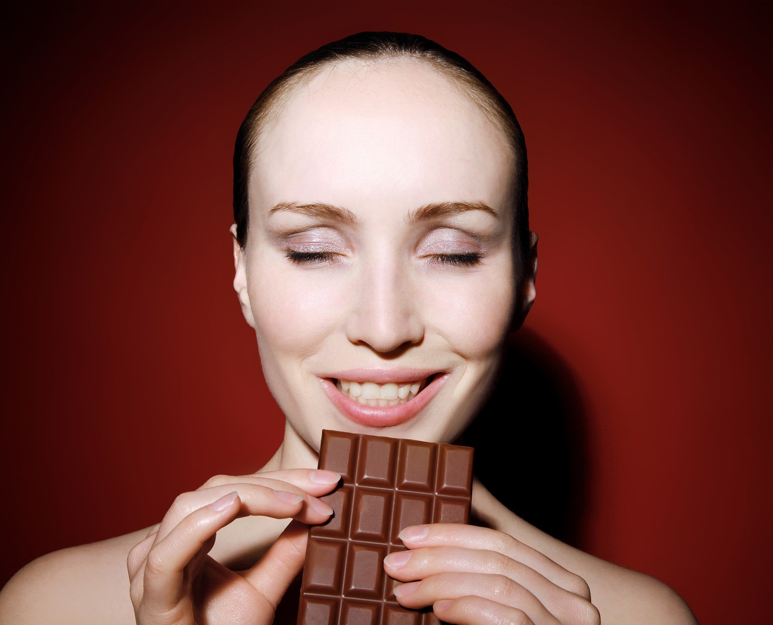 A woman eating chocolate. Click to learn about our 8 week custom keto meal plan.
