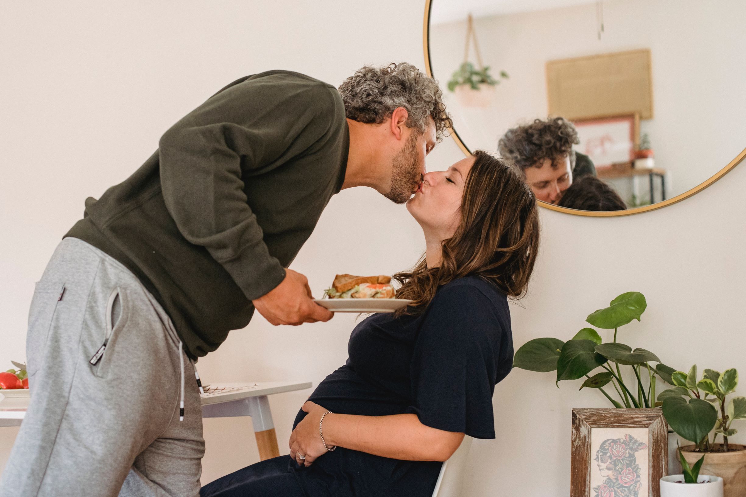 Photo of a pregnant couple with food at a table. Click to learn about getting a customized keto diet plan designed based on your activity level, food preferences, weight goals, and other personal criteria.